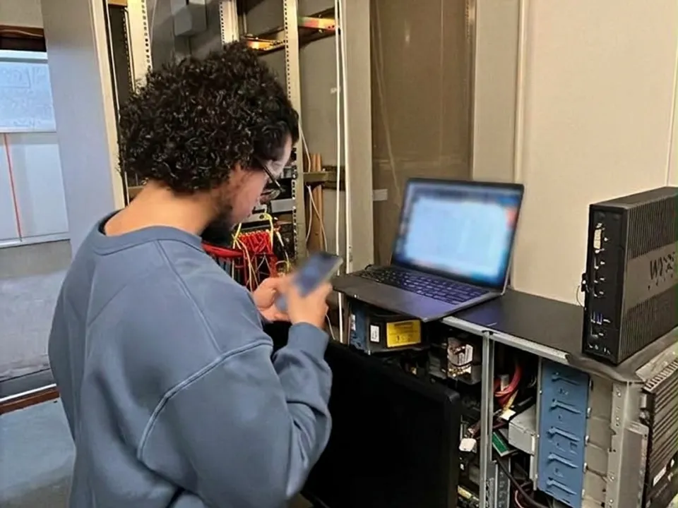 Ammar van ICT Productions stelt bij een serverkast een Synology NAS in